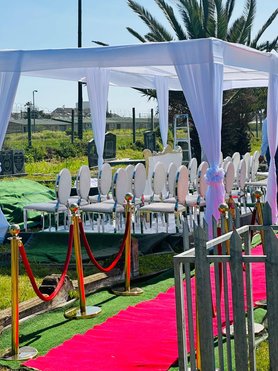 Outdoor tent setup with red carpet and VIP rope stands